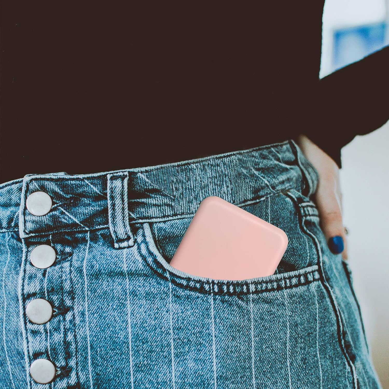 A pink smartphone tucked into the pocket of a person wearing denim jeans, showcasing a casual style.