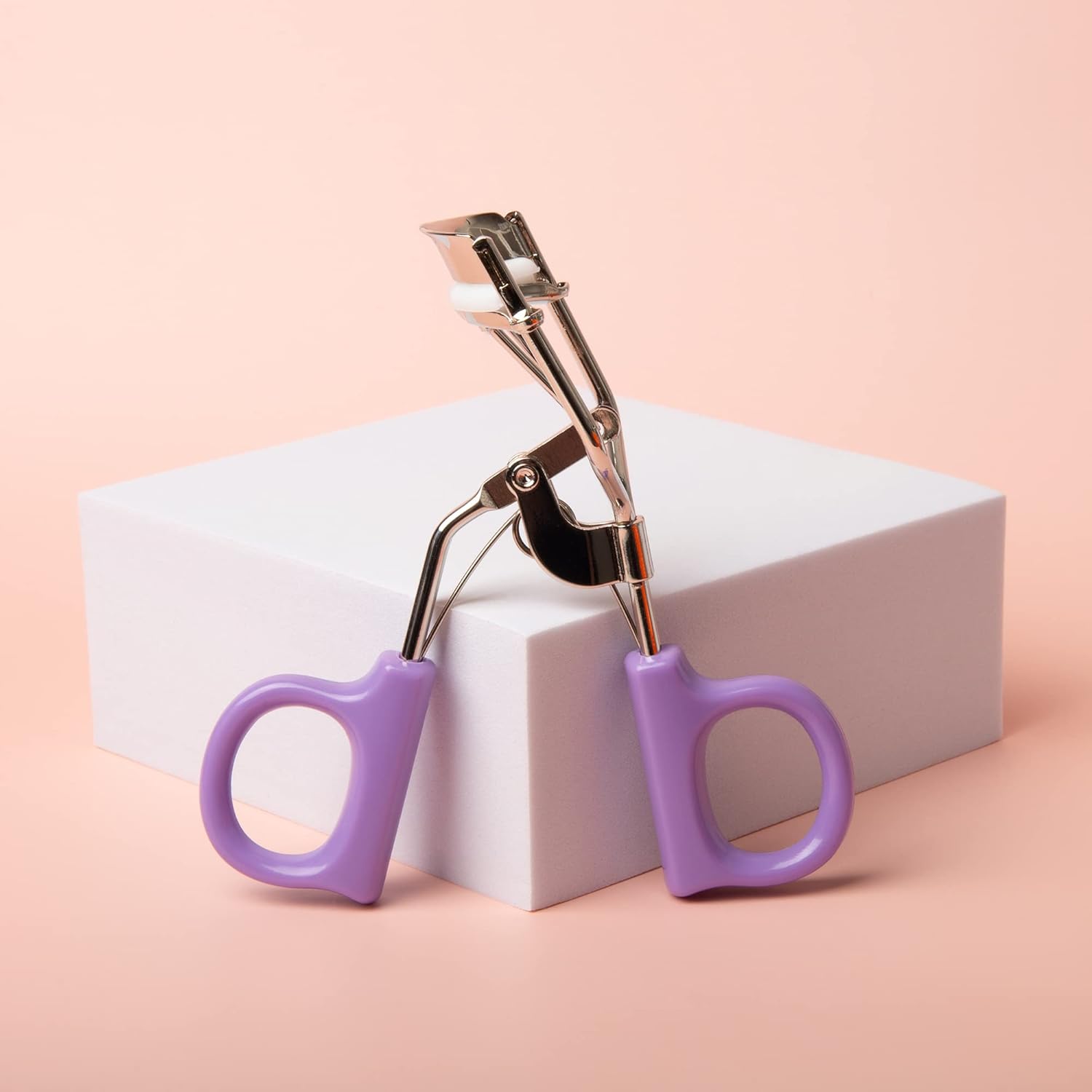 Herbionyx Professional Eyelash Curler displayed on a white box with purple silicone grips.